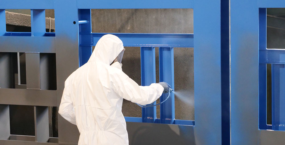 Verniciatore COMMI al lavoro su una struttura in acciaio verniciata blu